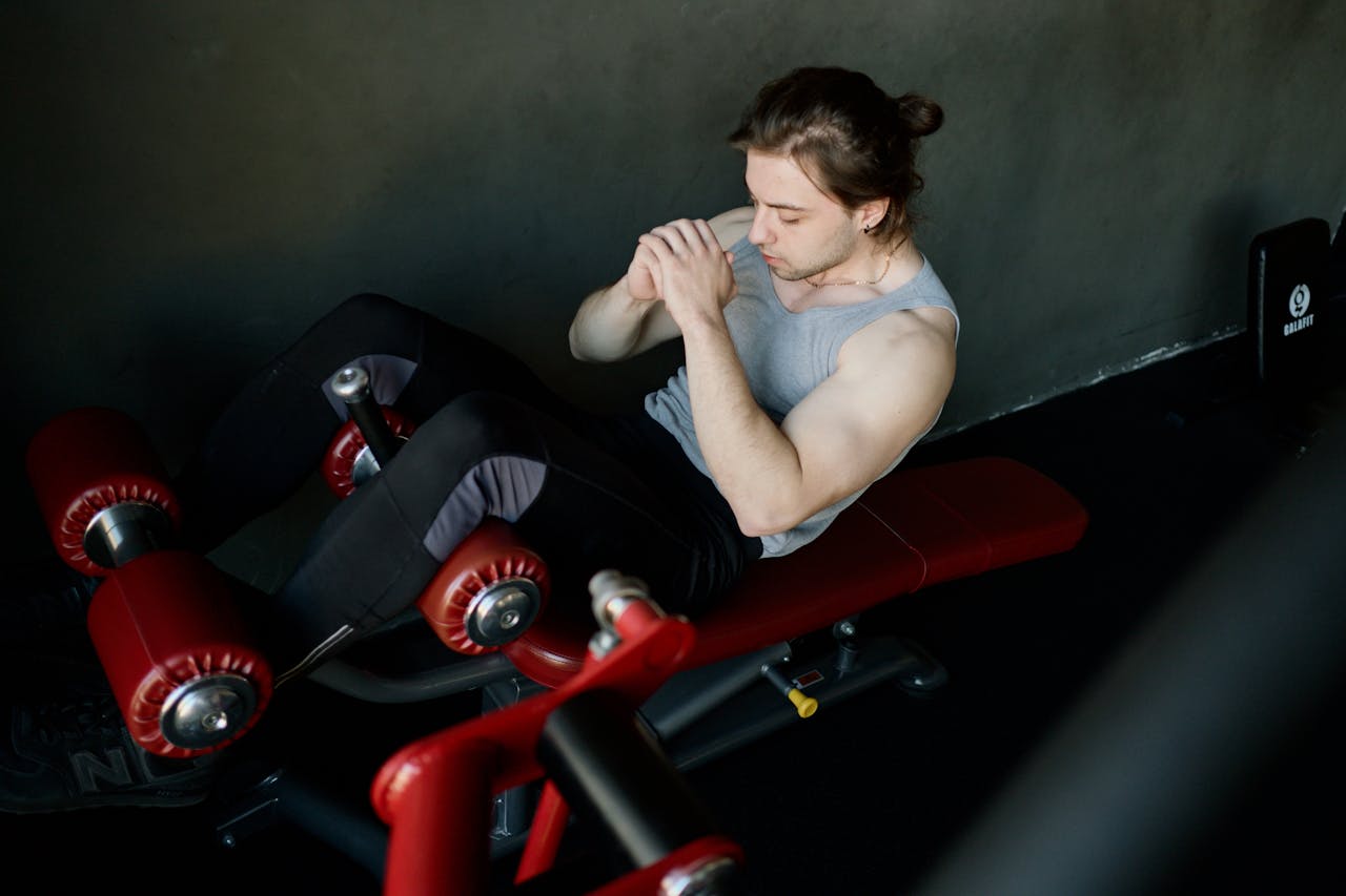 Offerings A focused man performs abdominal exercises on gym equipment, highlighting fitness and determination.